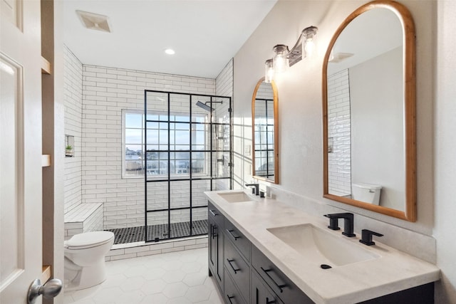 bathroom featuring vanity, a shower with shower door, tile patterned floors, and toilet