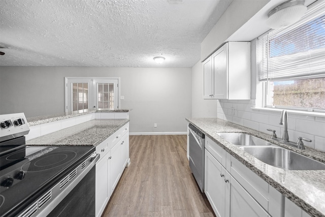 kitchen with sink, a textured ceiling, stainless steel appliances, decorative backsplash, and white cabinets