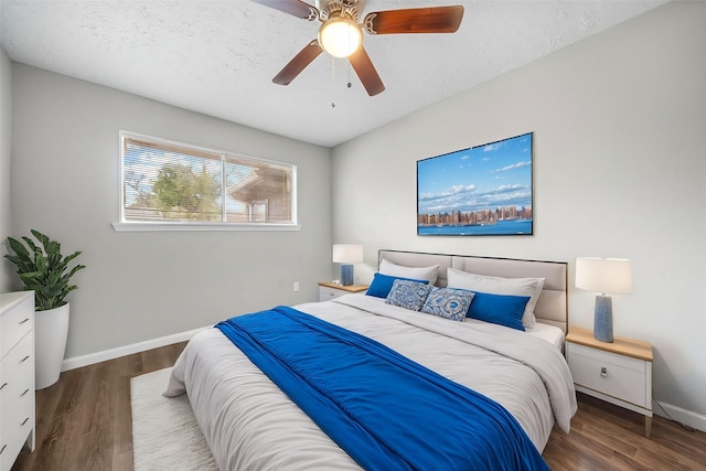 bedroom featuring dark hardwood / wood-style floors, a textured ceiling, and ceiling fan