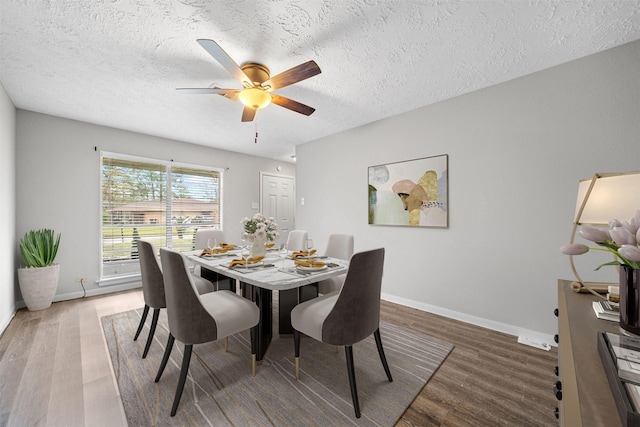 dining room featuring ceiling fan, hardwood / wood-style floors, and a textured ceiling