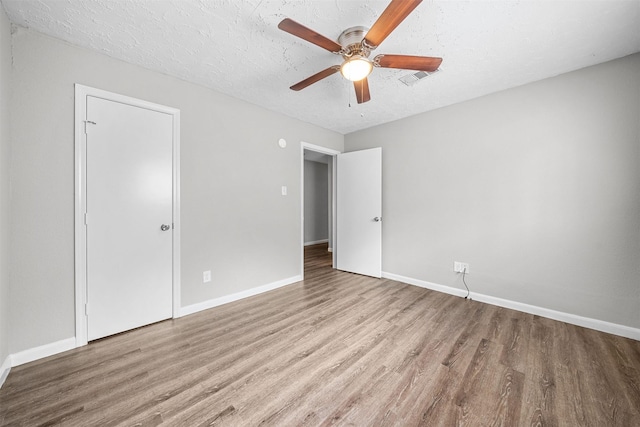 unfurnished bedroom with a textured ceiling, ceiling fan, and light wood-type flooring