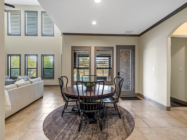 tiled dining area featuring crown molding