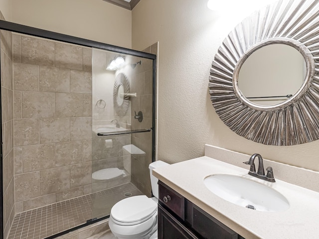 bathroom featuring vanity, toilet, and a shower with door