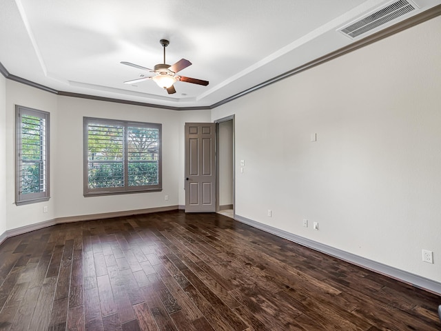 unfurnished room with dark hardwood / wood-style floors, ceiling fan, ornamental molding, and a tray ceiling