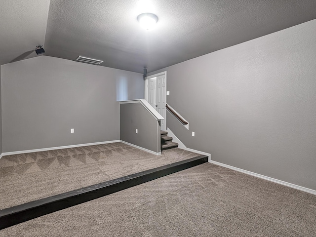 basement featuring carpet floors and a textured ceiling