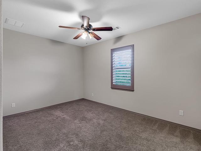 empty room featuring ceiling fan and carpet