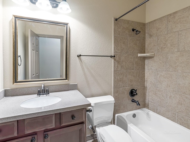 full bathroom featuring tiled shower / bath, vanity, and toilet