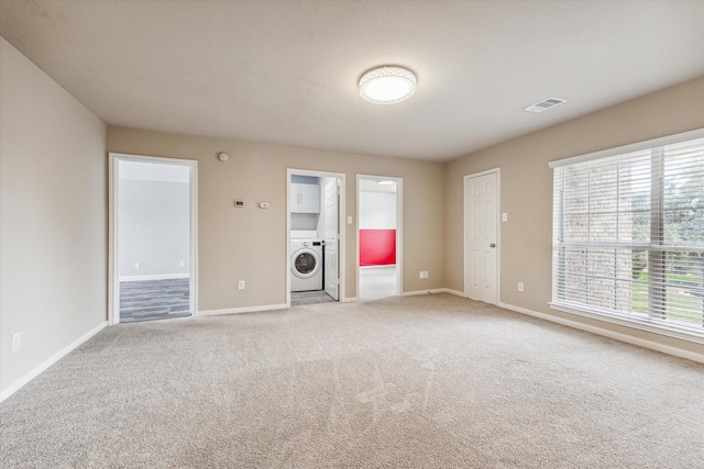 unfurnished living room with washer / dryer and light colored carpet