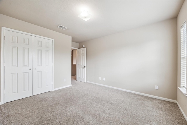 unfurnished bedroom with a closet and carpet flooring