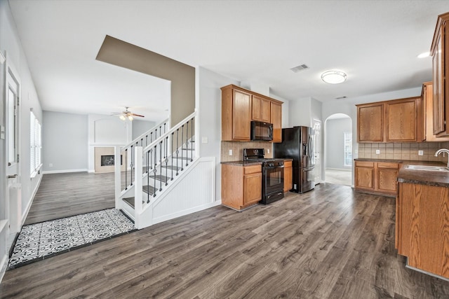 kitchen with plenty of natural light, dark hardwood / wood-style flooring, sink, and black appliances