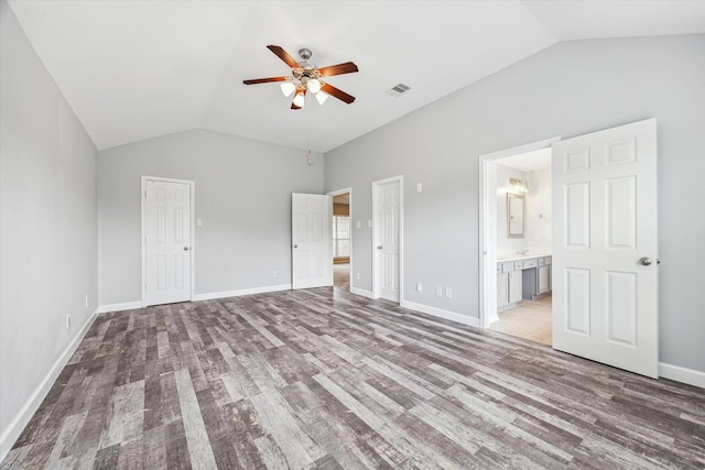 unfurnished bedroom with ensuite bath, vaulted ceiling, ceiling fan, and hardwood / wood-style flooring