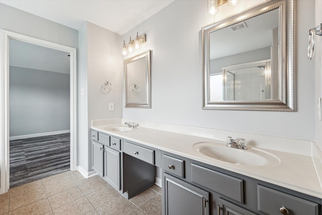 bathroom with walk in shower, vanity, and tile patterned flooring