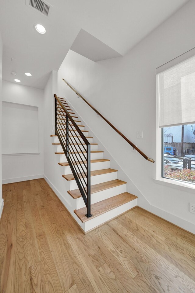 staircase with hardwood / wood-style floors