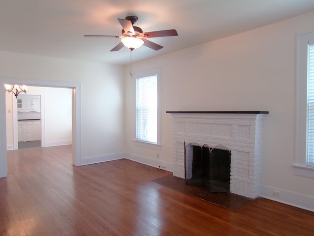 unfurnished living room with a fireplace, dark hardwood / wood-style floors, and ceiling fan