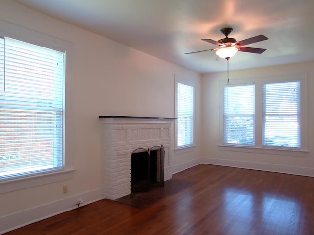 unfurnished living room featuring ceiling fan, a fireplace, and dark hardwood / wood-style floors