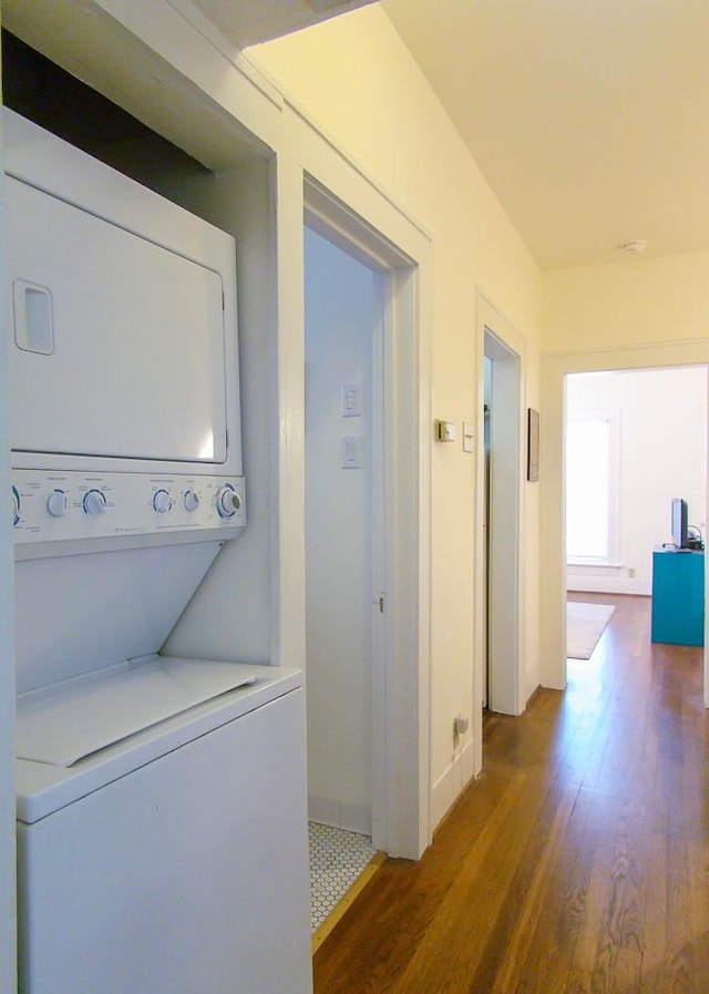 laundry room with stacked washer / dryer and dark hardwood / wood-style floors