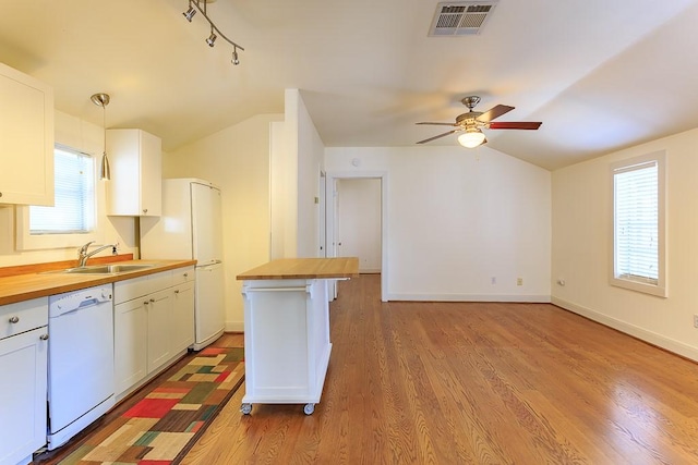 kitchen featuring white appliances, white cabinets, butcher block countertops, and decorative light fixtures