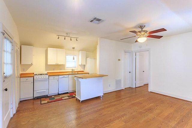 kitchen with sink, white appliances, light hardwood / wood-style flooring, white cabinets, and kitchen peninsula