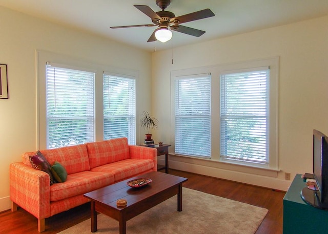 living room featuring ceiling fan and dark hardwood / wood-style floors