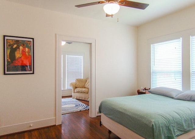 bedroom featuring ceiling fan, dark hardwood / wood-style floors, and multiple windows