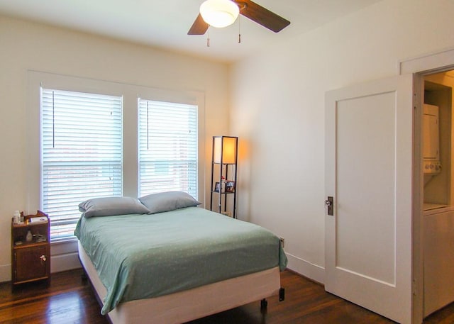 bedroom featuring multiple windows, dark hardwood / wood-style floors, and ceiling fan