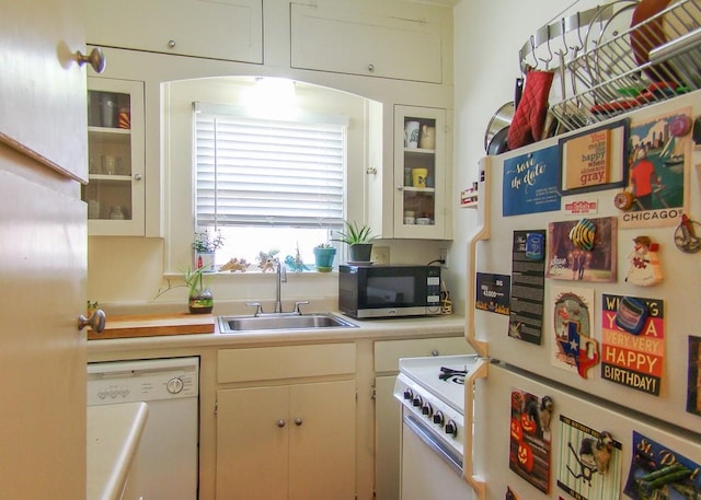 kitchen featuring white cabinetry, white appliances, and sink