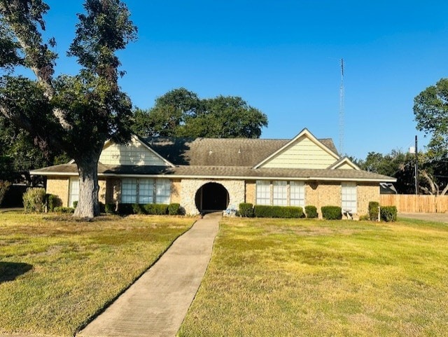 view of front of property featuring fence and a front lawn