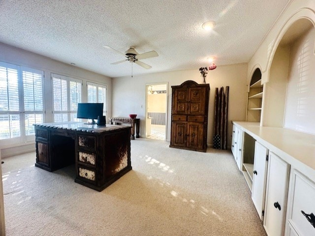 office area with light colored carpet, plenty of natural light, a textured ceiling, and ceiling fan