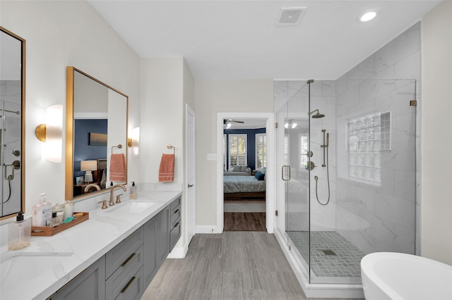 bathroom featuring vanity, separate shower and tub, and hardwood / wood-style floors