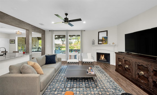 living room with ceiling fan and dark hardwood / wood-style floors