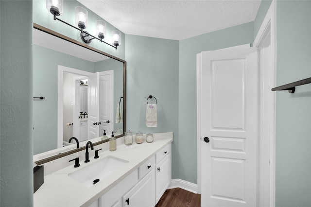 bathroom featuring vanity, hardwood / wood-style floors, and a textured ceiling