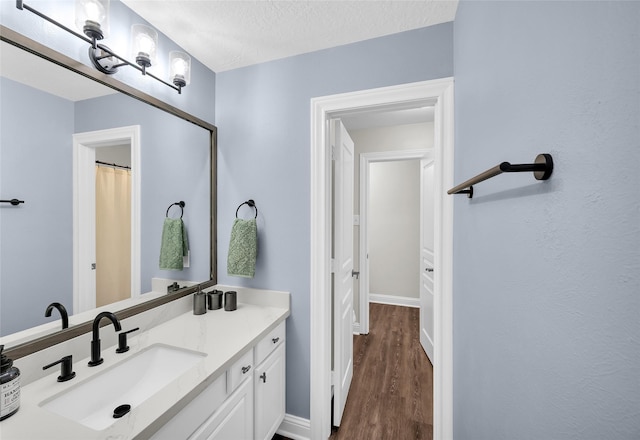 bathroom with vanity, wood-type flooring, and a textured ceiling