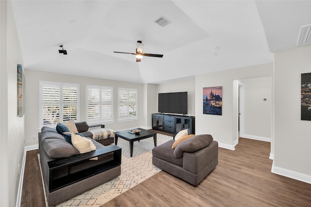 living room with ceiling fan, wood-type flooring, and vaulted ceiling