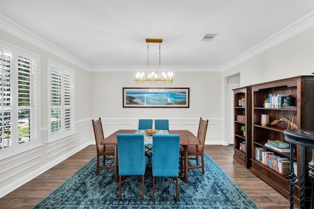 dining space with crown molding, dark hardwood / wood-style floors, and an inviting chandelier