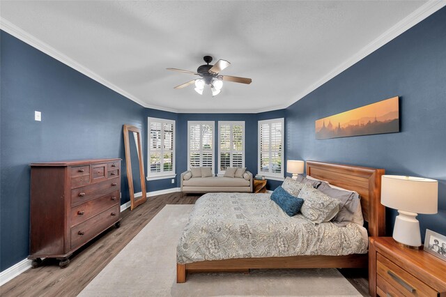 bedroom featuring crown molding, ceiling fan, and wood-type flooring