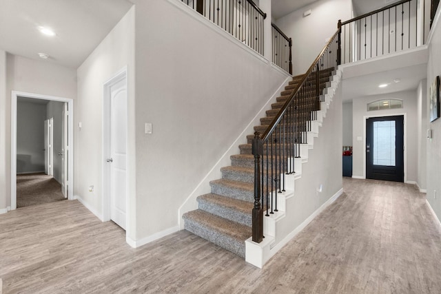 foyer with a towering ceiling and light hardwood / wood-style flooring