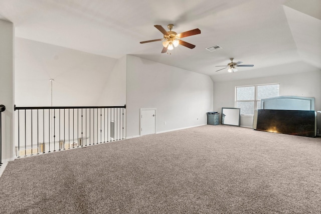 unfurnished living room with ceiling fan, vaulted ceiling, and carpet