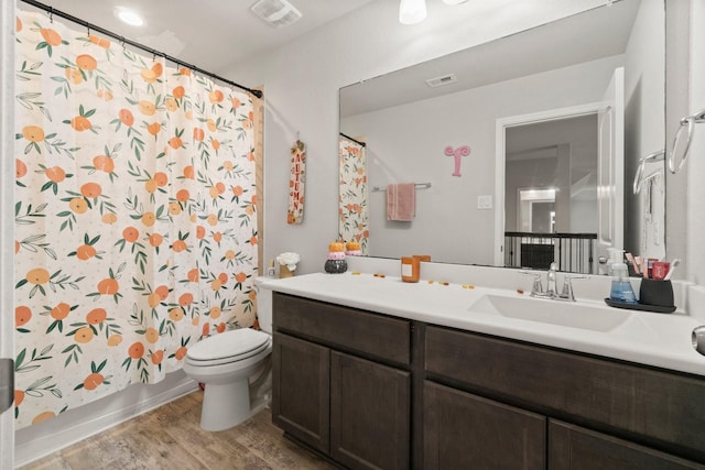 full bathroom with vanity, shower / tub combo, hardwood / wood-style flooring, and toilet