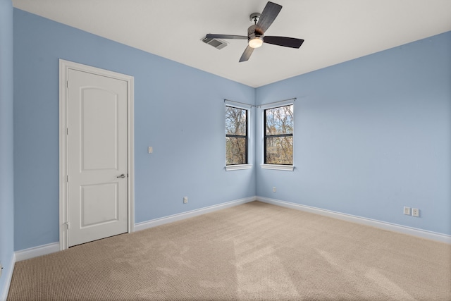 carpeted spare room with ceiling fan