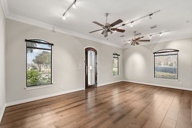 empty room featuring hardwood / wood-style floors, ornamental molding, a wealth of natural light, and ceiling fan