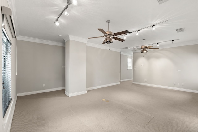 carpeted spare room featuring crown molding, track lighting, and ceiling fan