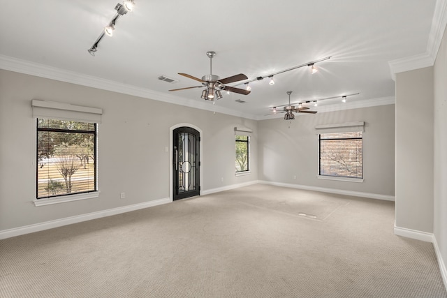 carpeted empty room featuring crown molding, plenty of natural light, rail lighting, and ceiling fan