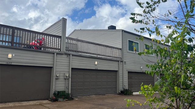 view of side of property featuring a garage and a balcony