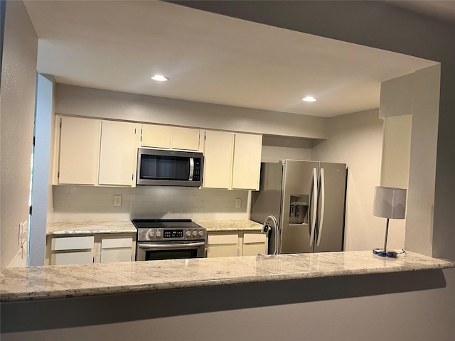 kitchen with white cabinetry, light stone countertops, appliances with stainless steel finishes, and backsplash