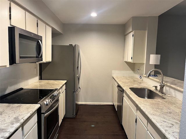 kitchen featuring sink, white cabinetry, appliances with stainless steel finishes, dark hardwood / wood-style floors, and decorative backsplash