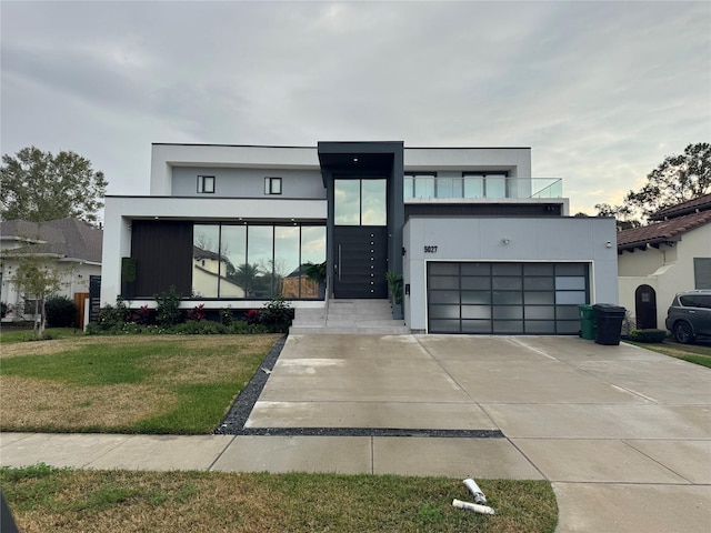 contemporary home featuring a garage and a front lawn