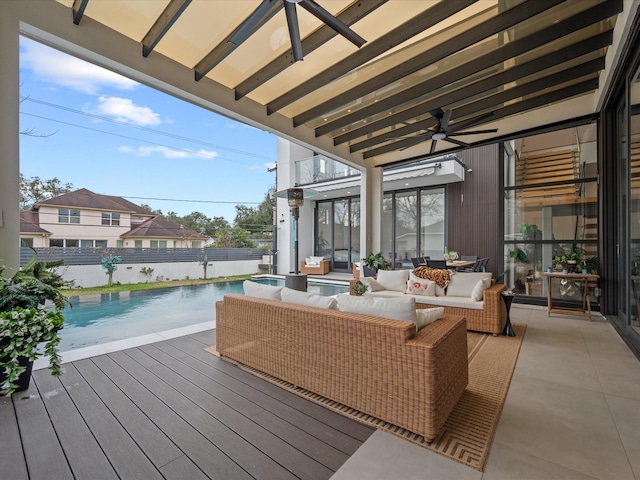 deck with an outdoor hangout area, ceiling fan, fence, and a fenced in pool