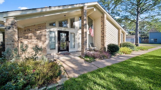 property entrance with a lawn