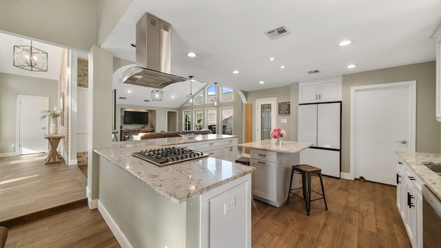 kitchen with a kitchen island, island range hood, white cabinets, a kitchen breakfast bar, and stainless steel appliances