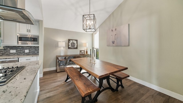 dining area featuring lofted ceiling, dark hardwood / wood-style floors, and a notable chandelier